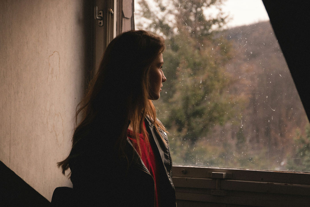 woman-standing-in-front-of-window-looking-out-by-benjamin-voros-at-unsplash