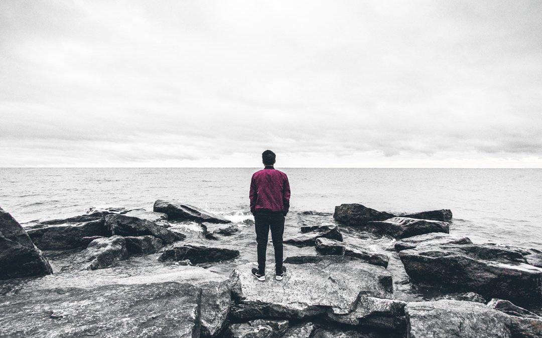 man-standing-on-the-rocks-watching-the-sea-by-warren-8iwdsT-unplash